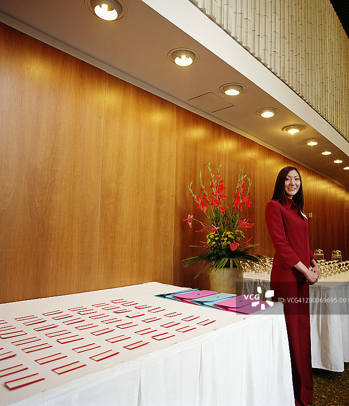 站在一桌玻璃和身份徽章之间的女人，肖像图片素材