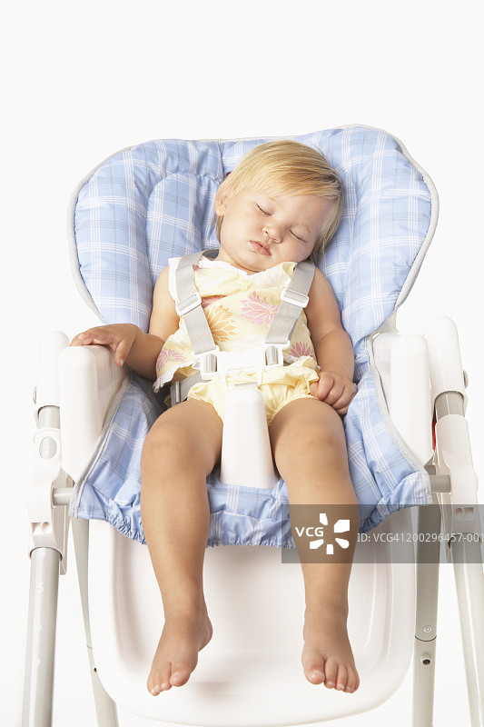女婴(12-15个月)睡在高椅上图片素材