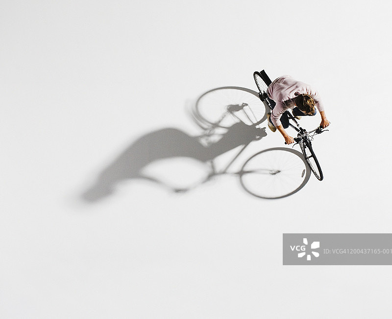 男人骑着自行车在白色的背景，俯视图片素材