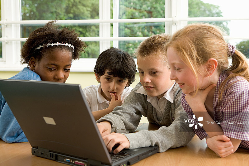 儿童(7-12岁)在教室使用笔记本电脑图片素材