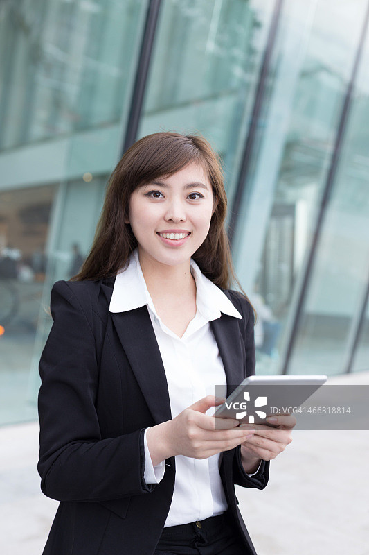 亚洲成功女商人在办公室走廊使用平板电脑图片素材