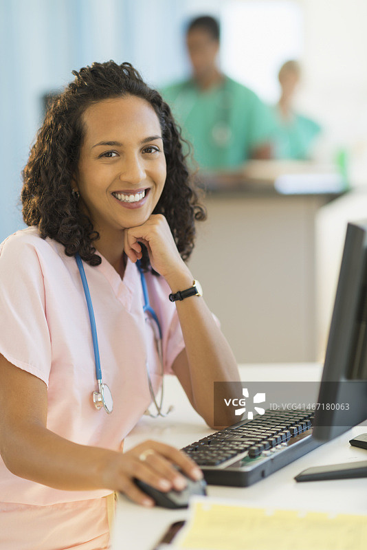 美国，新泽西州，泽西城，微笑的女医生在医院的桌子上工作的肖像图片素材