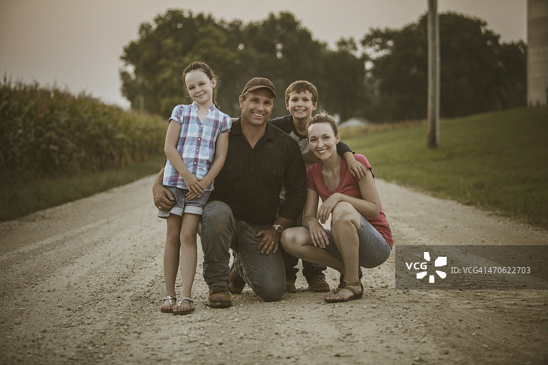 白人农民和家人在土路上微笑图片素材