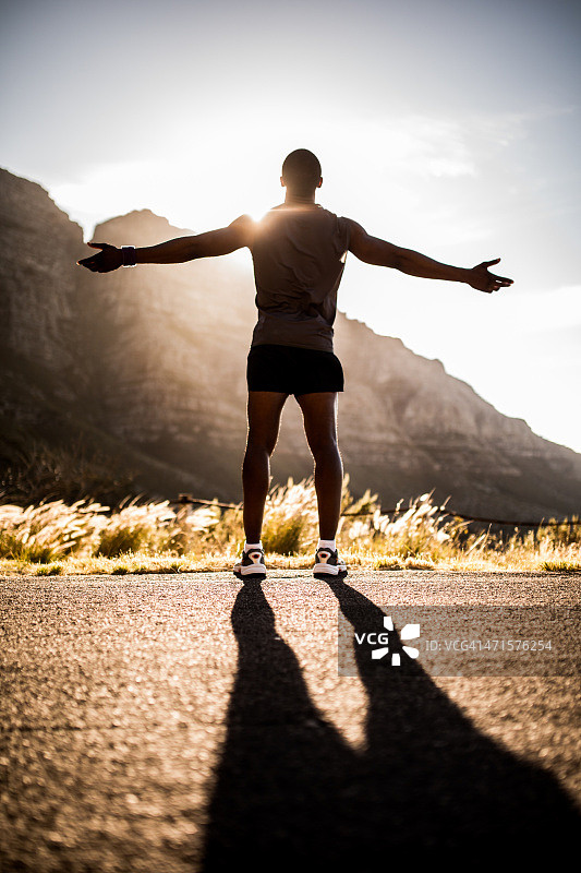 快乐健康的运动员一边跑步一边欣赏阳光图片素材