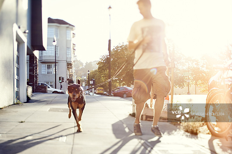 一个男人和他的狗在户外奔跑图片素材