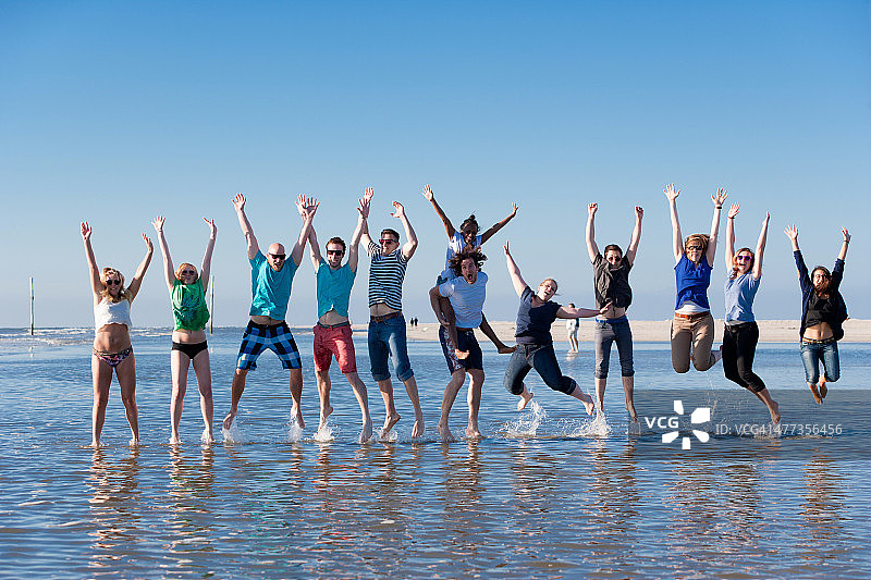 年轻人在德国圣彼得-奥丁海滩上跳着图片素材