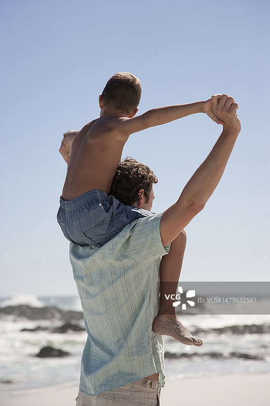 一位父亲让他的儿子骑在他的背上图片素材