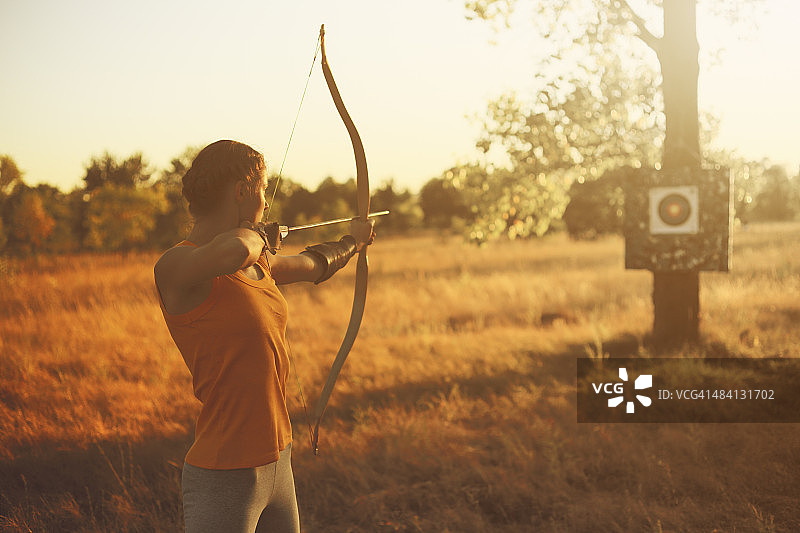 日落时分，田野上的女弓箭手图片素材