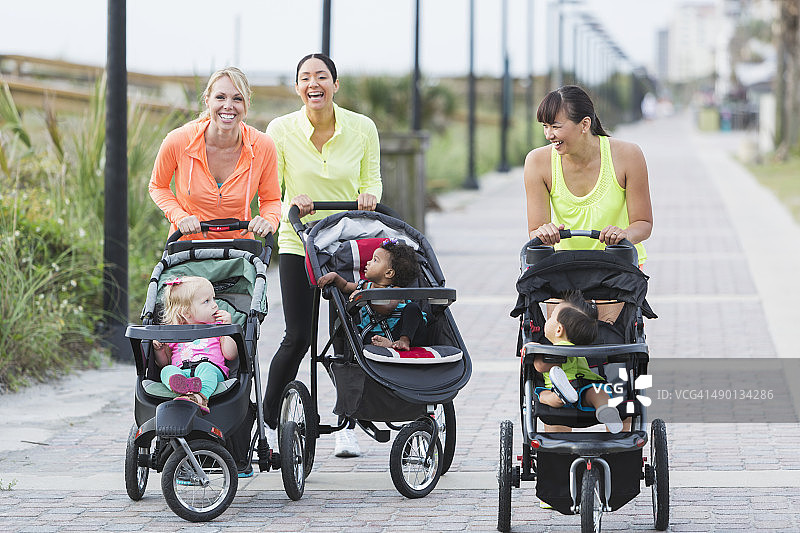 多种族母亲和婴儿在慢跑婴儿车图片素材