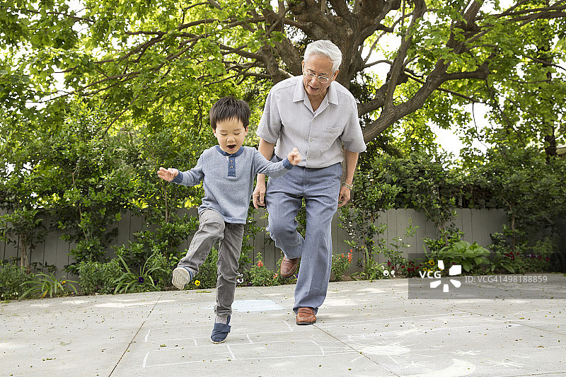 爷爷和孙子玩跳房子图片素材