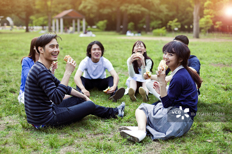 一群快乐的日本朋友在东京的公园里吃饭图片素材