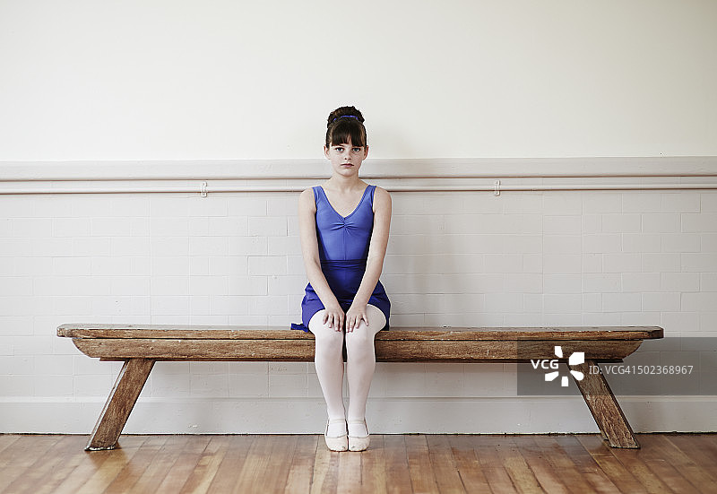 女芭蕾舞者坐在长椅上练习图片素材