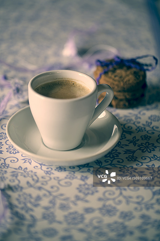 一杯咖啡和图案布上的巧克力饼干图片素材