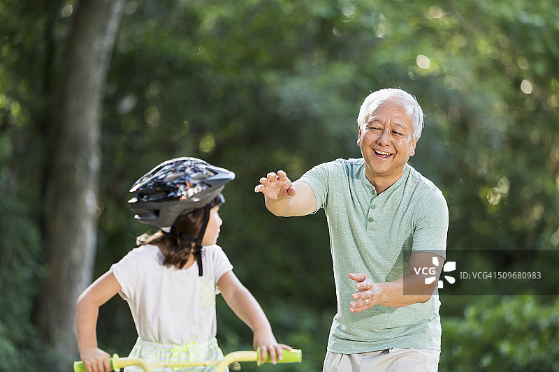 女孩骑着自行车，和爷爷在一起图片素材