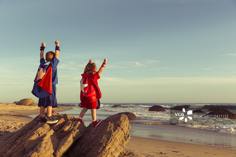 男孩和女孩装扮成超级英雄在加利福尼亚海滩上图片素材