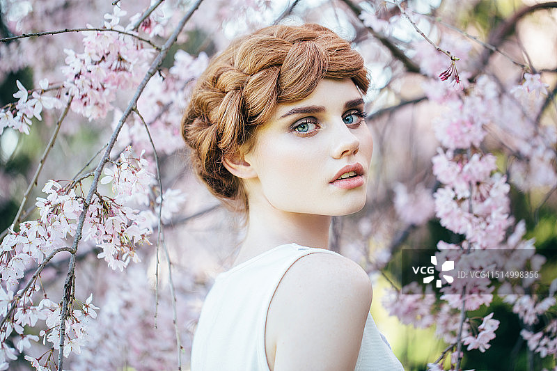 春天灌木丛背景上的美丽女孩图片素材