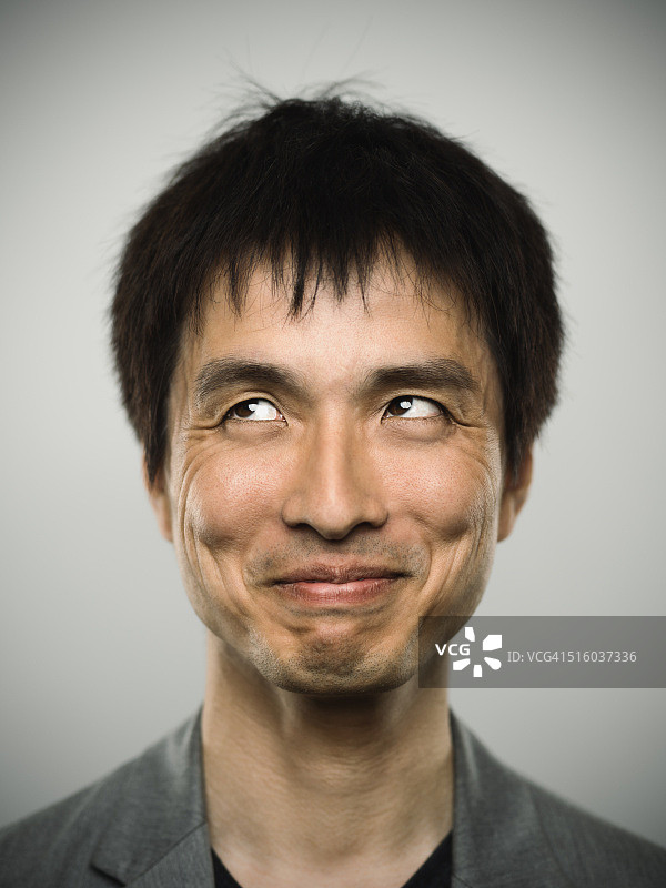 一个年轻的日本男人看着照相机的肖像图片素材