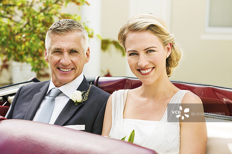 新娘和父亲坐在敞篷车的后座上图片素材