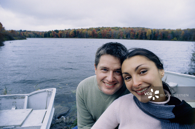 年轻的微笑夫妇在湖边图片素材