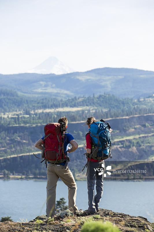 美国俄勒冈州，一对年轻夫妇站在岩石山上欣赏风景图片素材