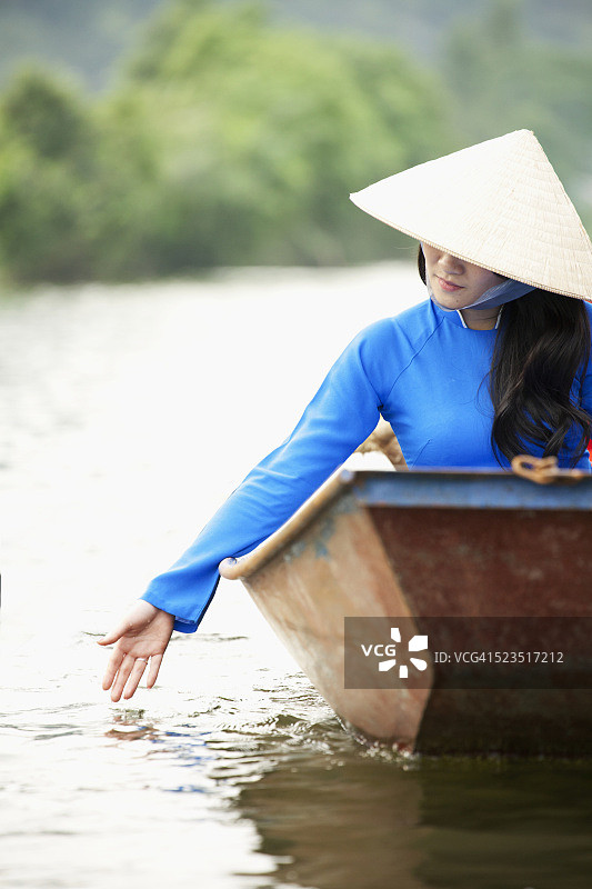 传统的越南妇女坐船旅行。图片素材