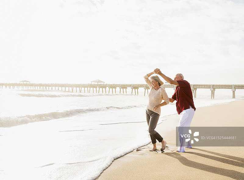 美国，佛罗里达，朱庇特，老年情侣在海滩上跳舞图片素材