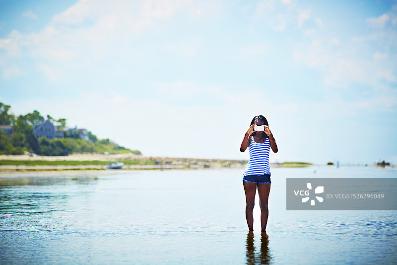 黑人少女在海滩上拍照图片素材