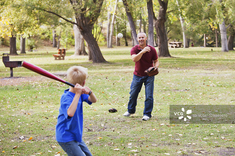 爸爸和儿子在公园里打棒球;加拿大亚伯达省的埃德蒙顿图片素材
