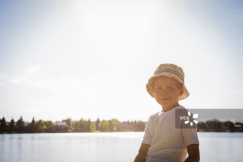 男孩的肖像(4-5)站在湖边图片素材