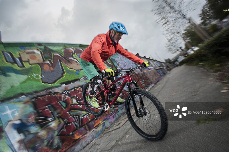 德国巴伐利亚，骑山地自行车的人在前轮上保持平衡进入城市图片素材