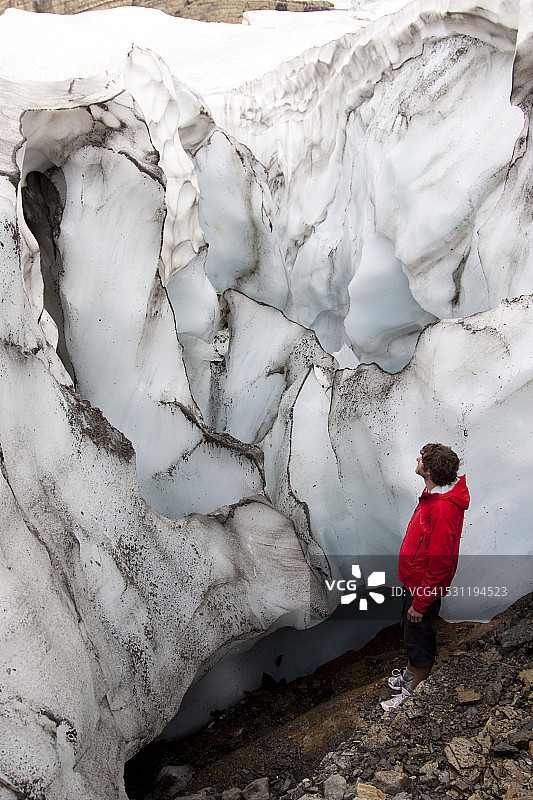 蒙大拿州冰川国家公园，一名男子站在冰川旁边。图片素材
