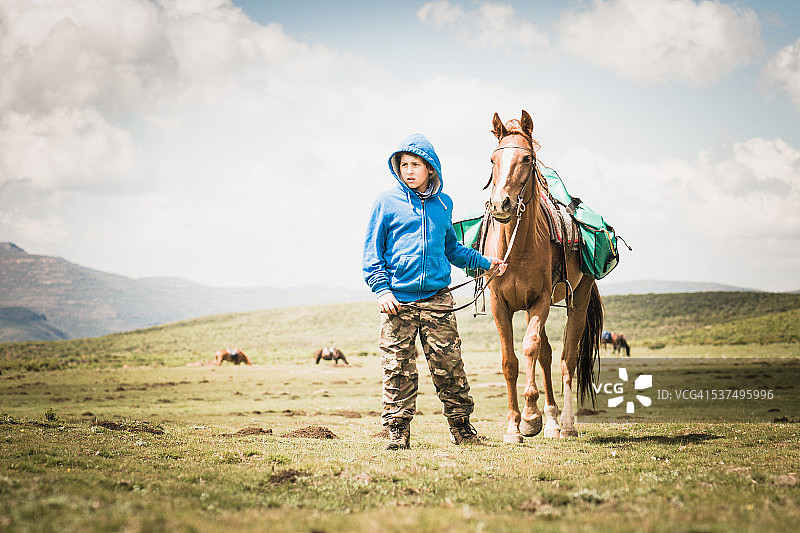 男孩和马在自然景观图片素材