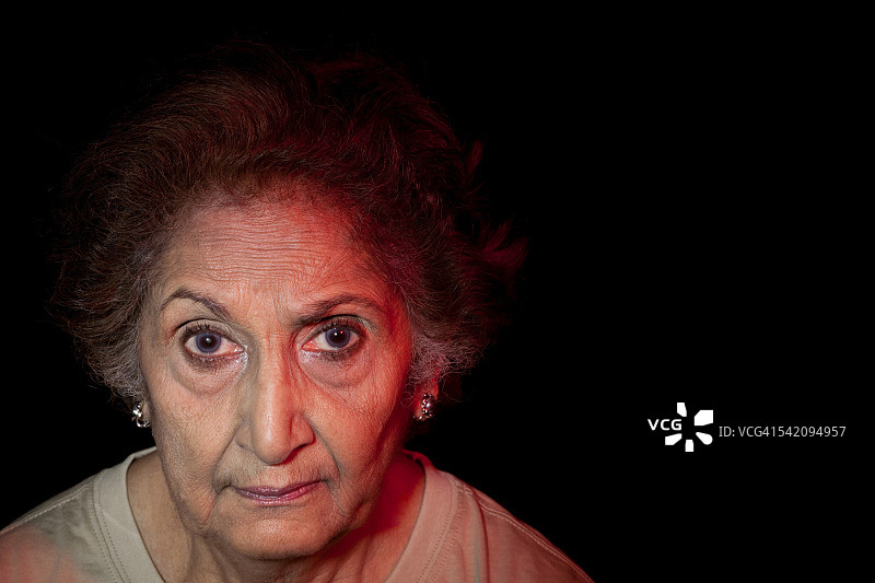 一个老年妇女的特写在黑色的背景图片素材