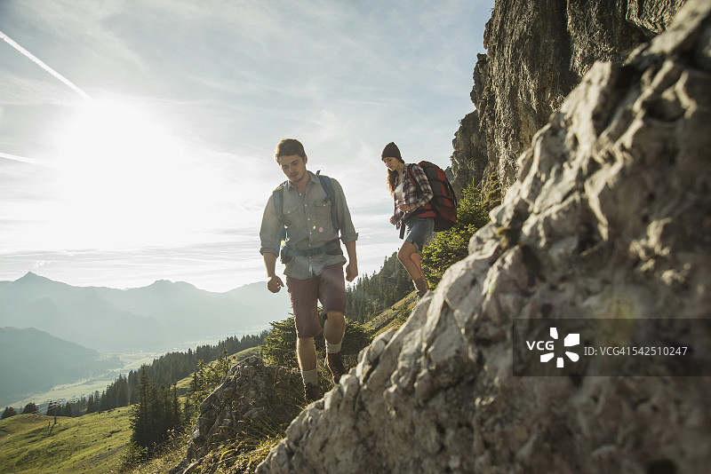 奥地利，蒂罗尔，坦海默·塔尔，一对在岩石上远足的年轻夫妇图片素材