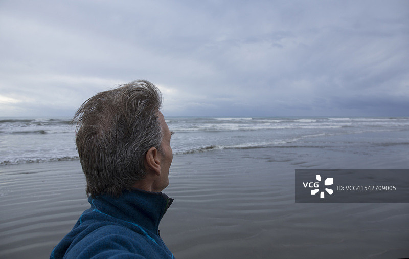 暴风雨天，人们从海滩望向大海图片素材