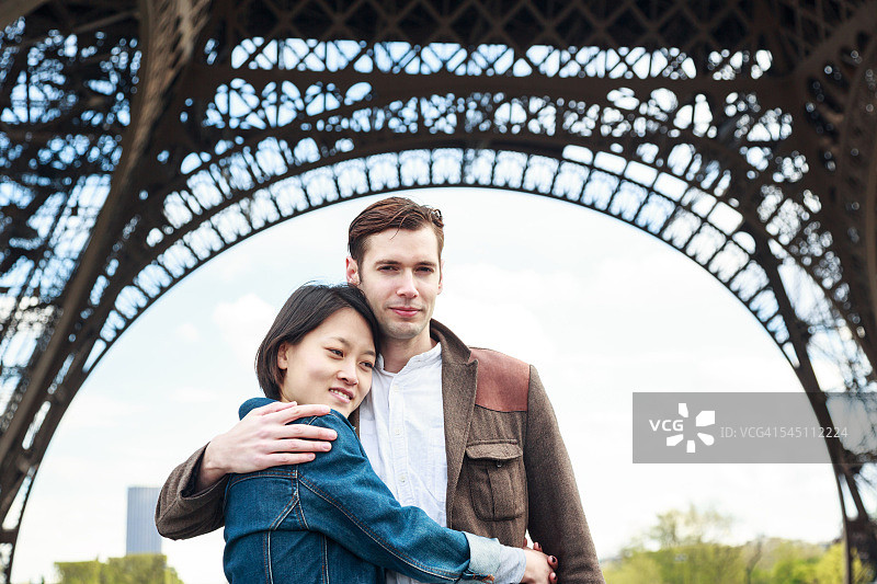 多民族夫妇有乐趣在巴黎附近的埃菲尔铁塔图片素材