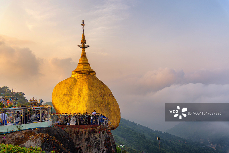 清晨景观日出与雾的Kyaiktiyo塔(金岩)黄昏与祈祷的人们和游客。Kyaiktiyo、缅甸。图片素材