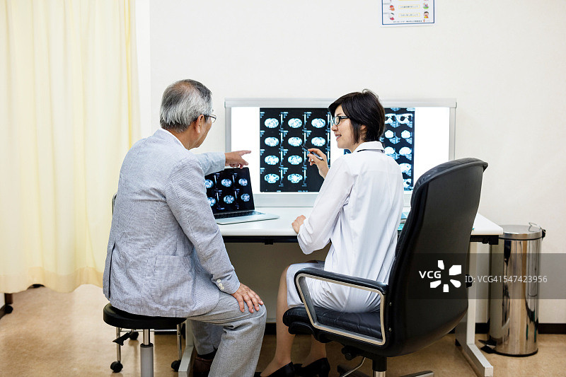 女医生显示MRI报告并解释患者图片素材