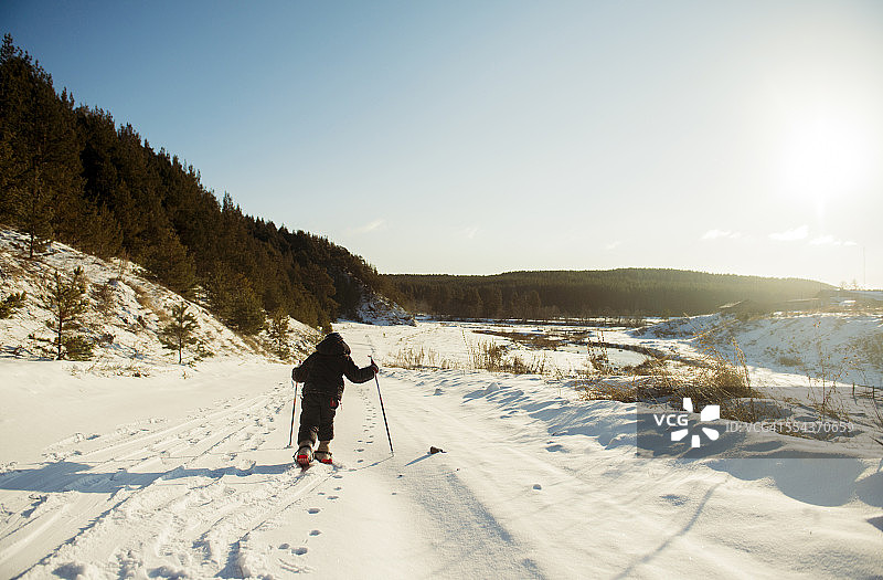 白人男孩越野滑雪在雪地里图片素材