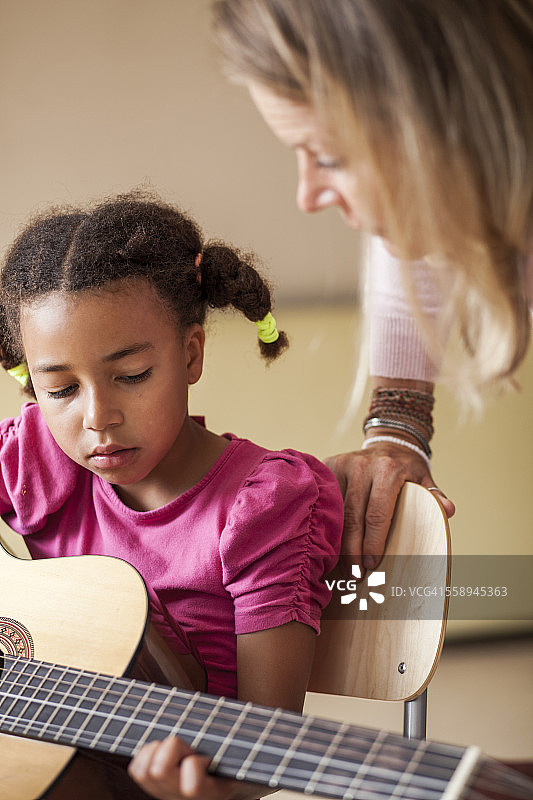 成熟的女老师教女孩弹吉他图片素材