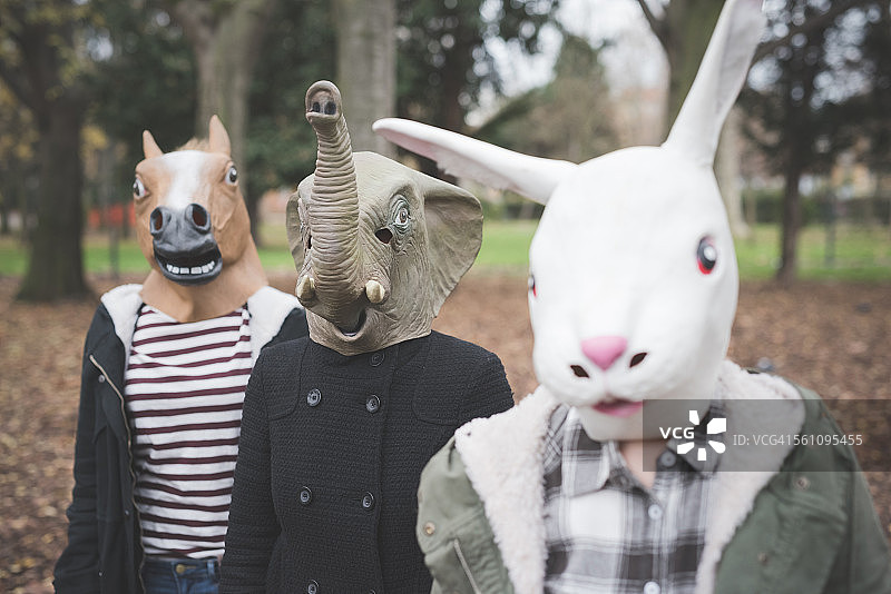 三姐妹戴着动物面具在公园里摆姿势图片素材