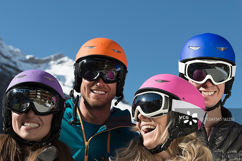 四个朋友戴着滑雪头盔和护目镜，笑个不停图片素材