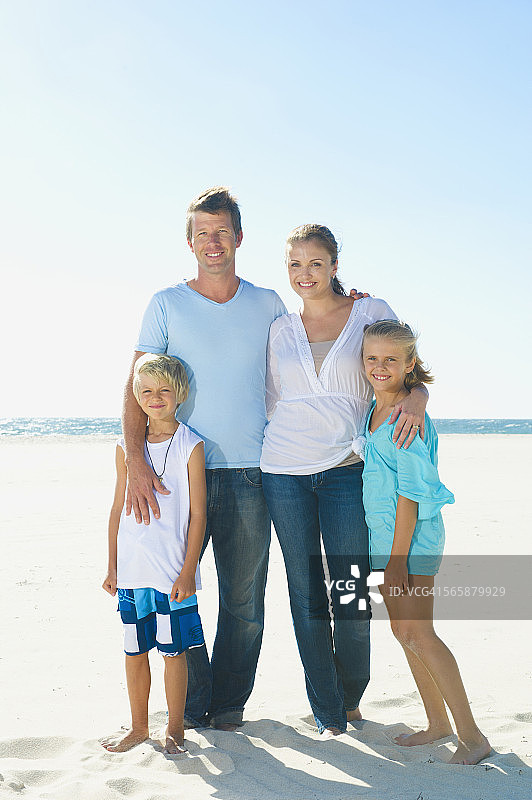 白人父母和孩子在海滩上微笑图片素材