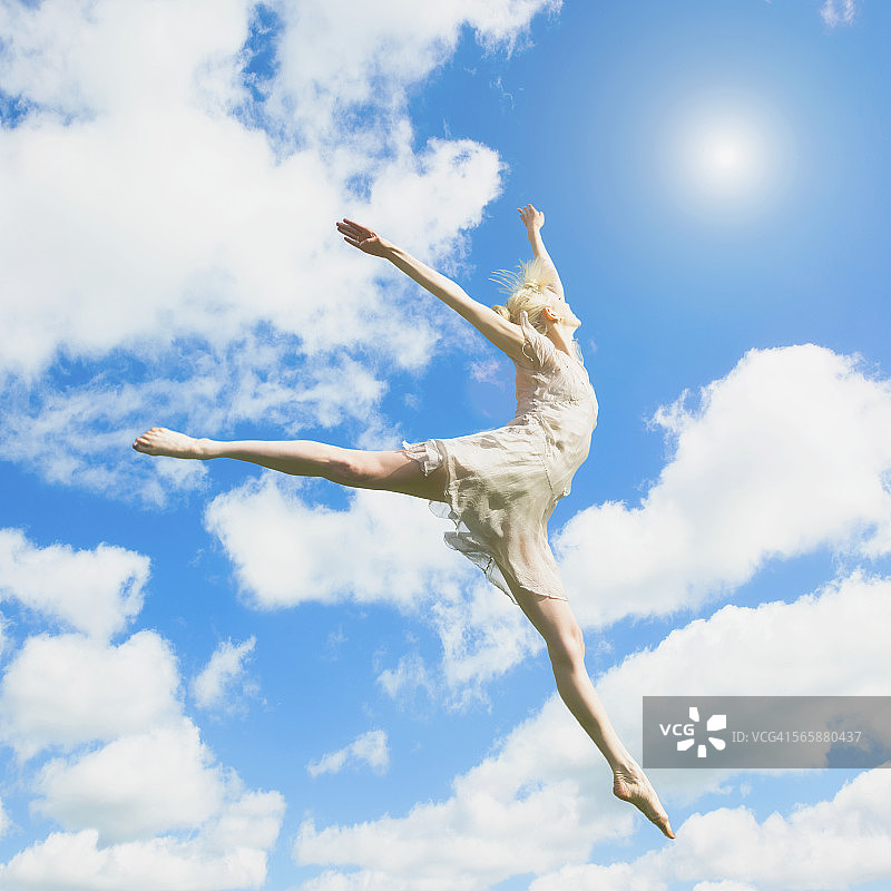 高加索芭蕾舞者在云下跳跃图片素材