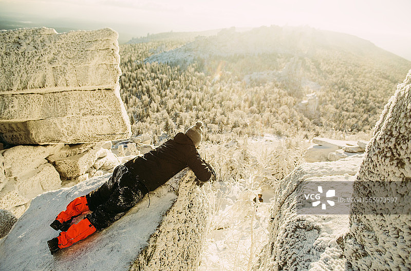 高加索徒步旅行者躺在积雪的岩层上图片素材