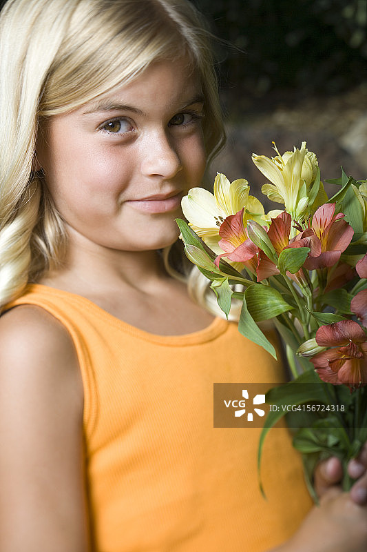 一个女孩拿着一束花的特写图片素材