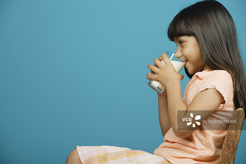 年轻女孩喝着一杯牛奶图片素材