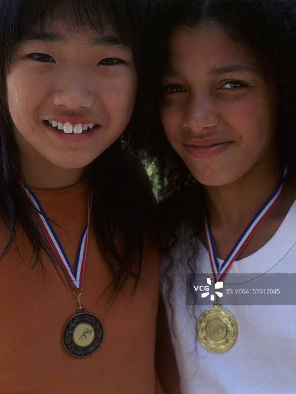 两个女孩的肖像微笑着与金属周围的脖子图片素材