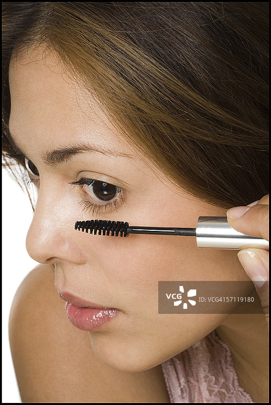 一个女人用睫毛膏在她的睫毛上的特写图片素材