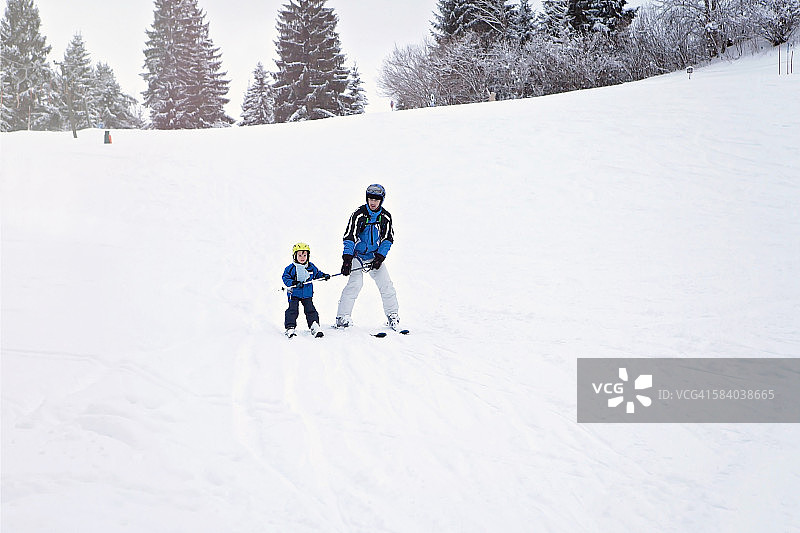 父亲教他的小孩滑雪图片素材